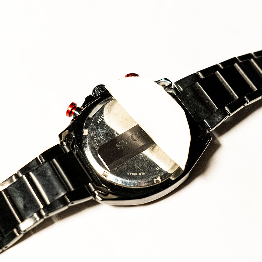 Wristwatch with concealed emergency tool secured beneath the case back to demonstrate discreet storage inside an everyday object.